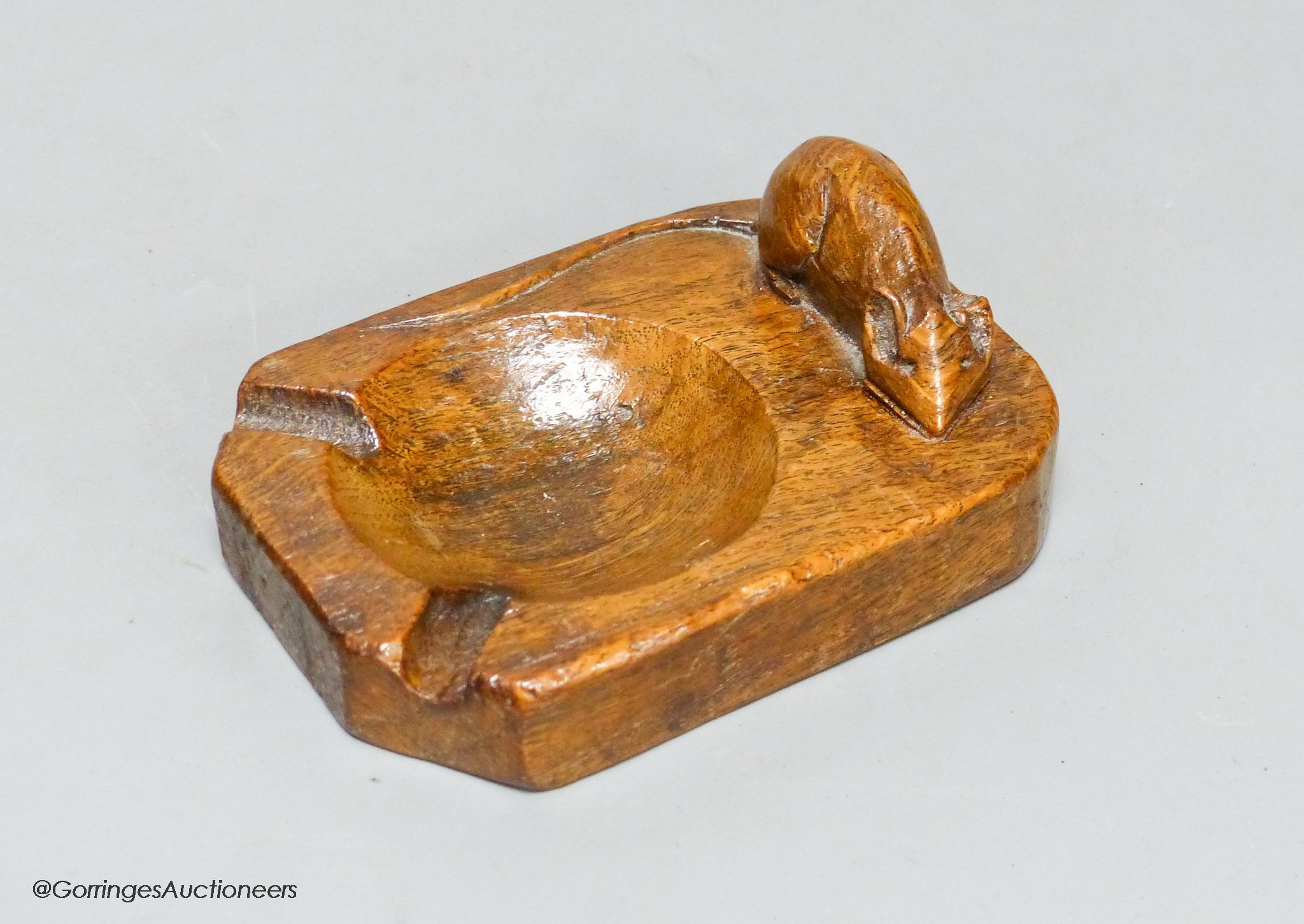 A Mouseman oak ashtray, width 10cm, slight loss to ear